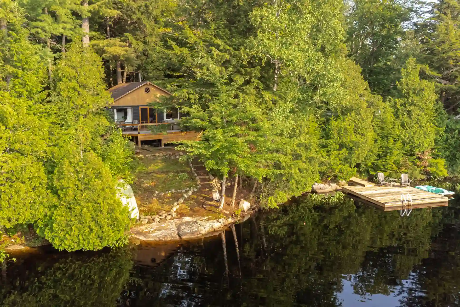 Secluded lakefront cabin tucked into forest with private dock, reflecting 2026 waterfront property market trends in coastal areas