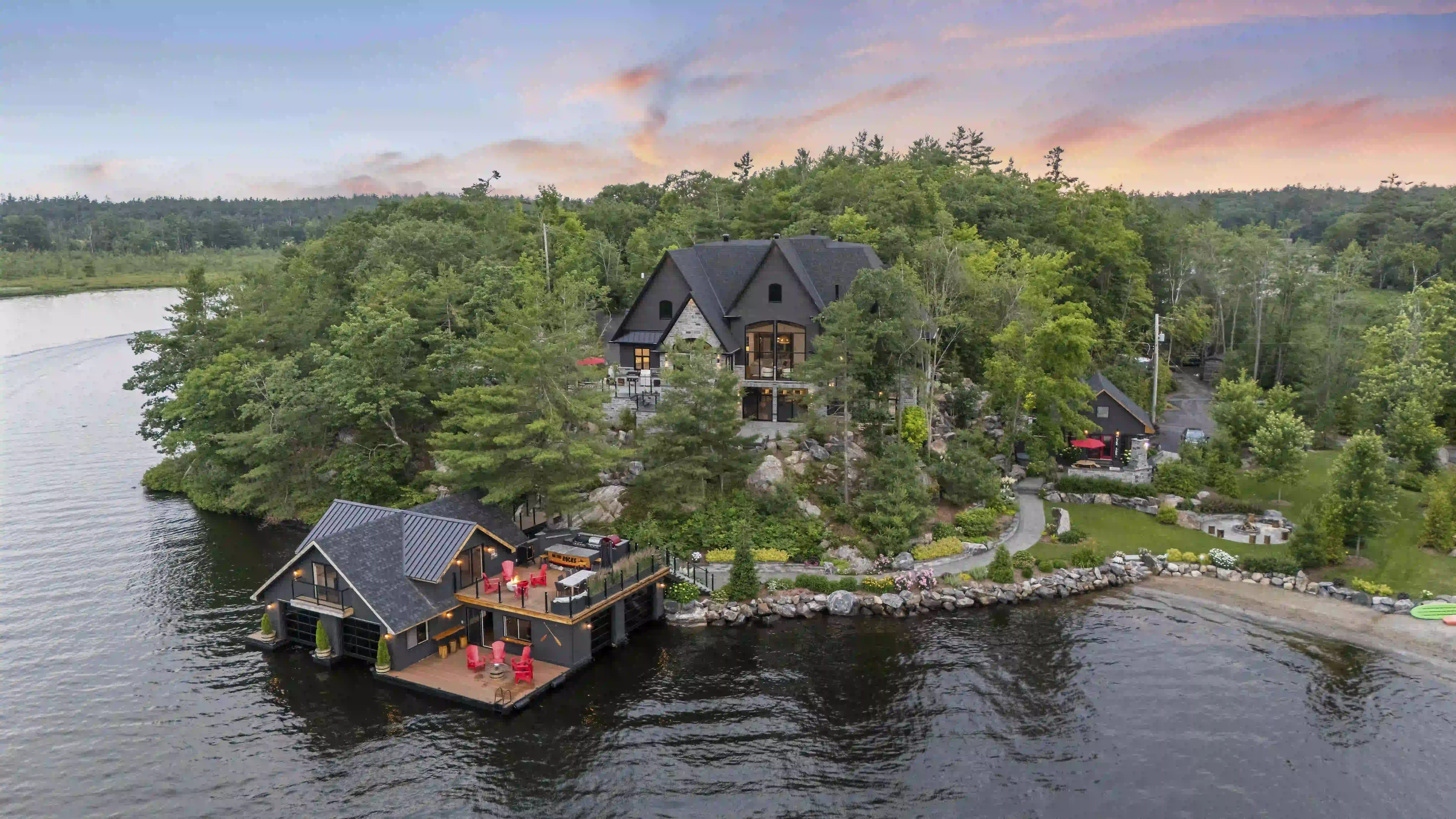 Luxury waterfront estate with boathouse and rooftop deck at sunset, the kind of property found in the strongest waterfront markets