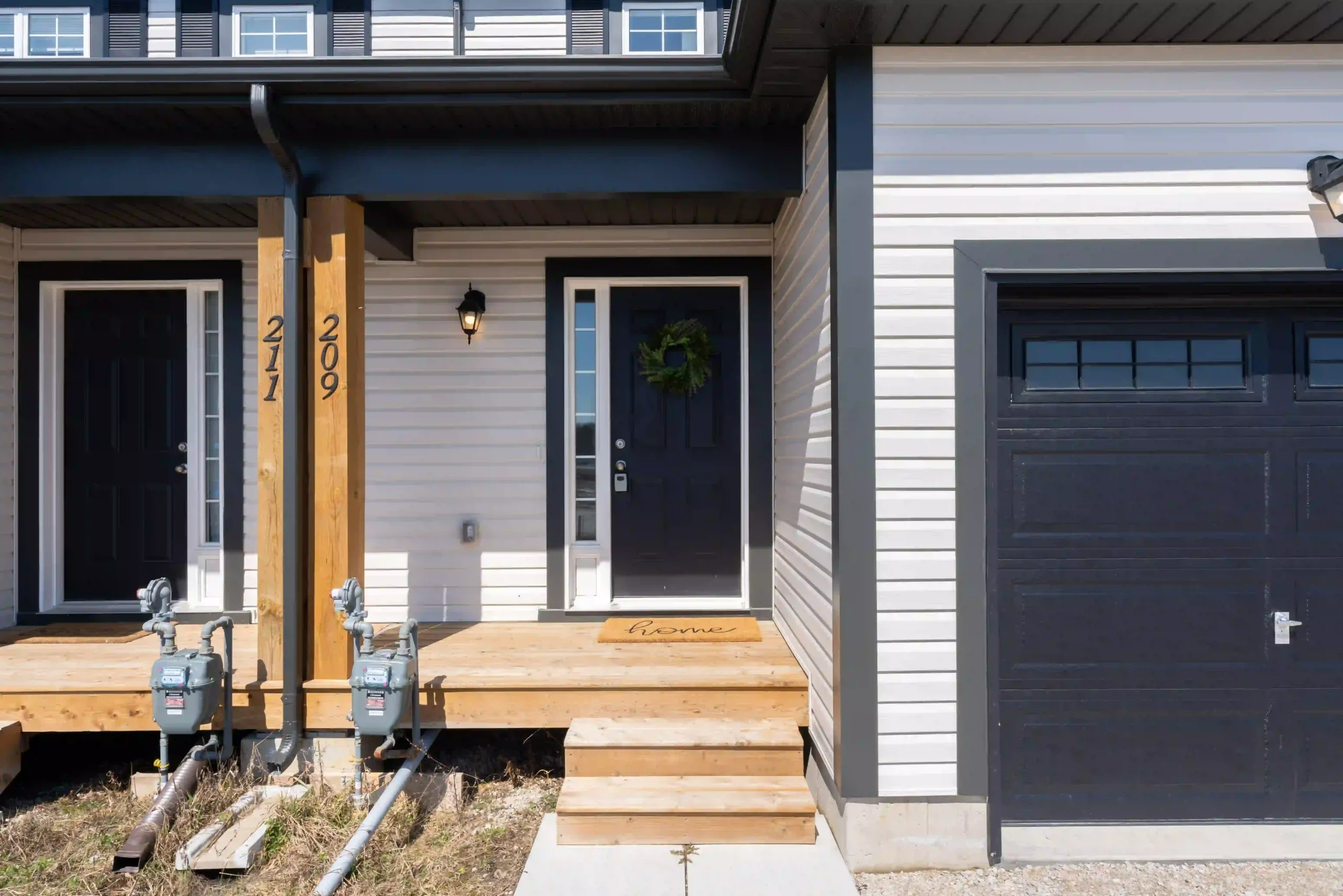 Townhome front entrance with visible gas meters and utility connections, the kind of infrastructure worth inspecting before buying a cottage